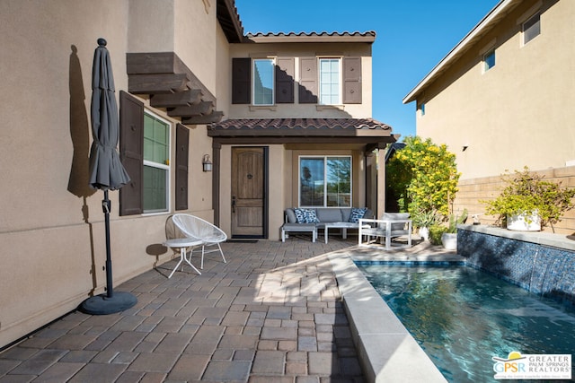 rear view of house with an outdoor hangout area, a fenced in pool, pool water feature, and a patio