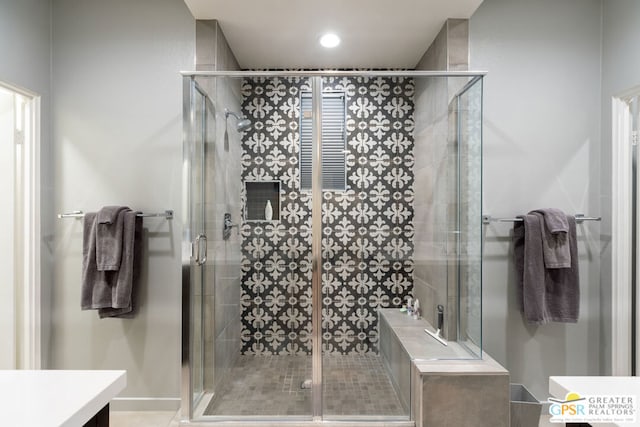 bathroom with a shower with shower door and vanity