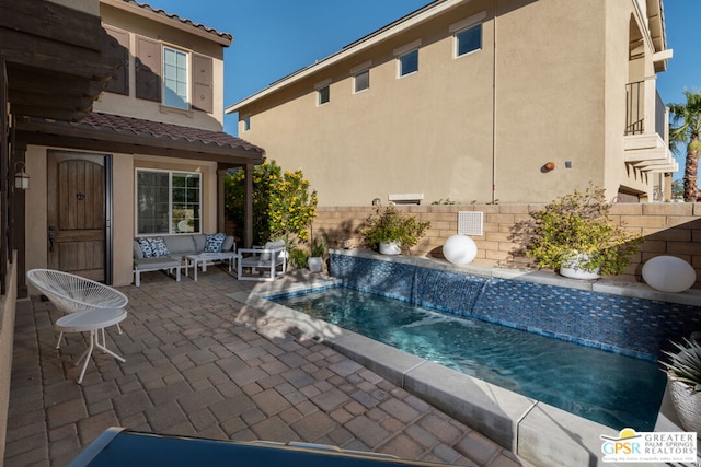 view of pool with pool water feature and a patio