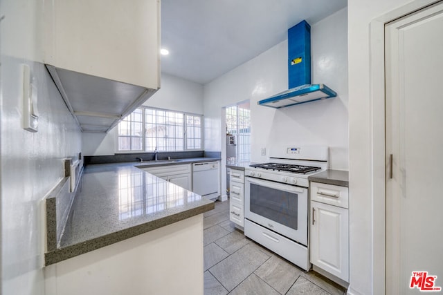 kitchen with extractor fan, kitchen peninsula, sink, white appliances, and white cabinetry