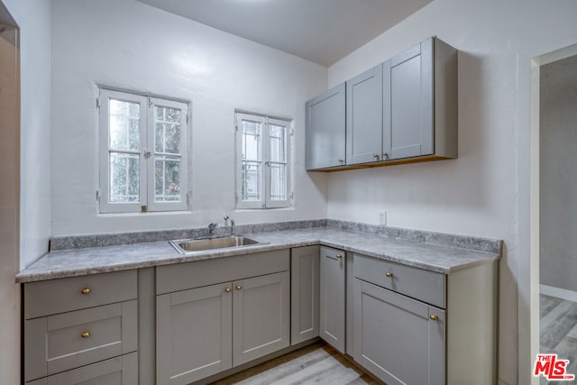 kitchen featuring light hardwood / wood-style floors, sink, and gray cabinets