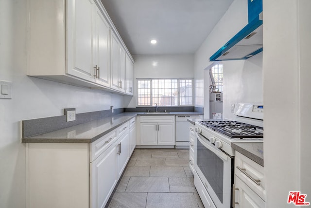 kitchen featuring sink, white appliances, white cabinets, and plenty of natural light