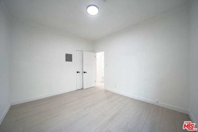 unfurnished room with light wood-type flooring and electric panel