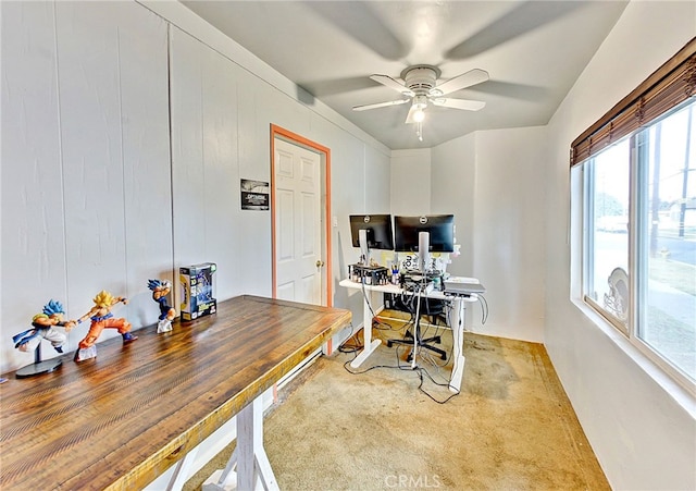 office area featuring ceiling fan and wood walls