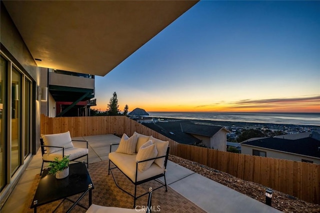 balcony at dusk with an outdoor living space and a patio