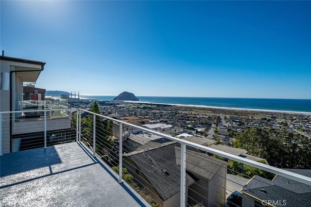 balcony featuring a view of the beach and a water view