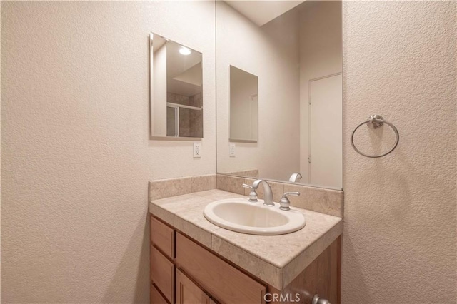 bathroom featuring a textured wall and vanity