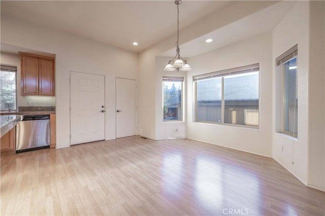 unfurnished dining area with light wood-type flooring, a sink, and recessed lighting