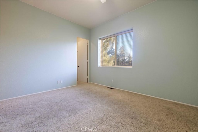 carpeted spare room with baseboards and visible vents