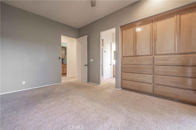 unfurnished bedroom featuring baseboards, a ceiling fan, and light colored carpet