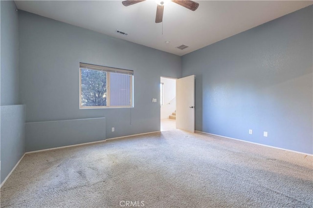 carpeted spare room featuring ceiling fan and visible vents