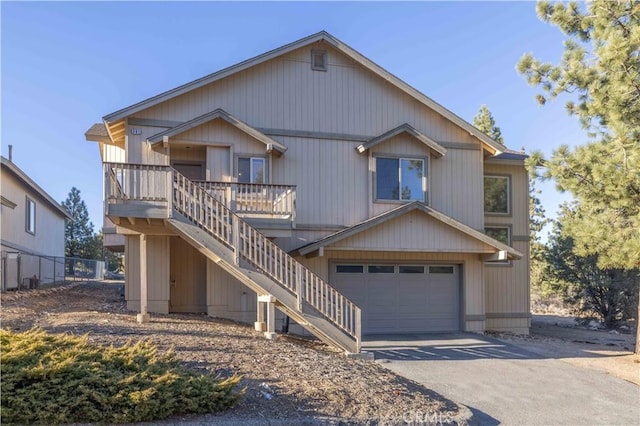 view of front of house featuring driveway, an attached garage, and stairway