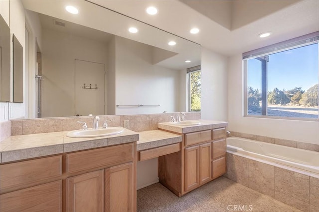 full bathroom featuring a sink, a bath, and double vanity