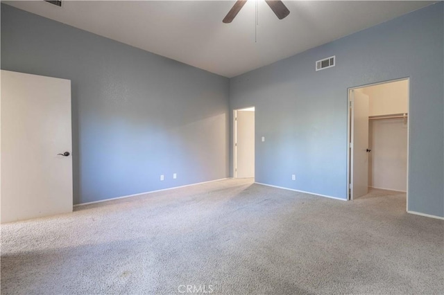 unfurnished room with carpet floors, visible vents, and a ceiling fan