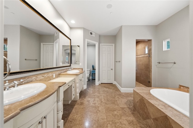 full bathroom featuring toilet, vanity, and independent shower and bath