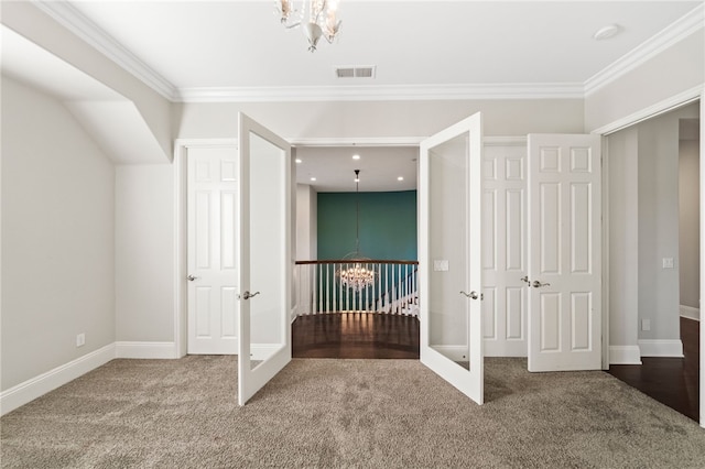 unfurnished bedroom featuring crown molding, french doors, carpet floors, and an inviting chandelier