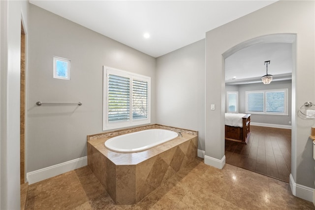 bathroom featuring tiled bath and tile patterned flooring