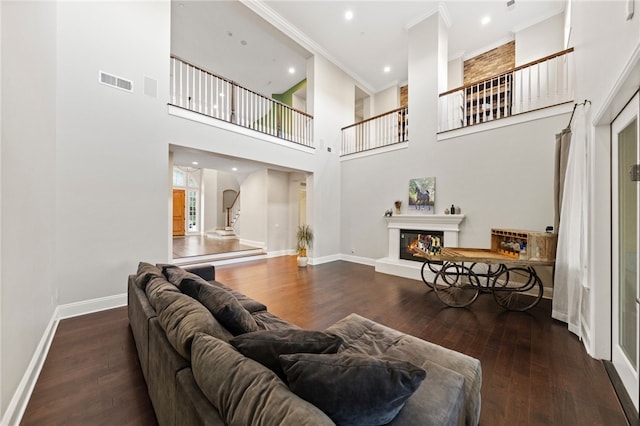 living room featuring a high ceiling, crown molding, and hardwood / wood-style flooring