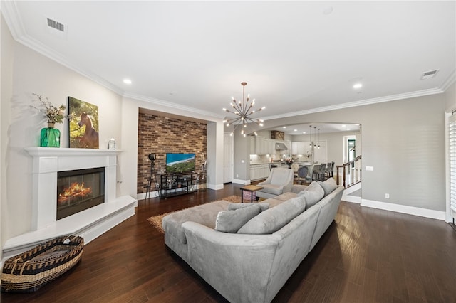 living room with dark hardwood / wood-style flooring, ornamental molding, and an inviting chandelier