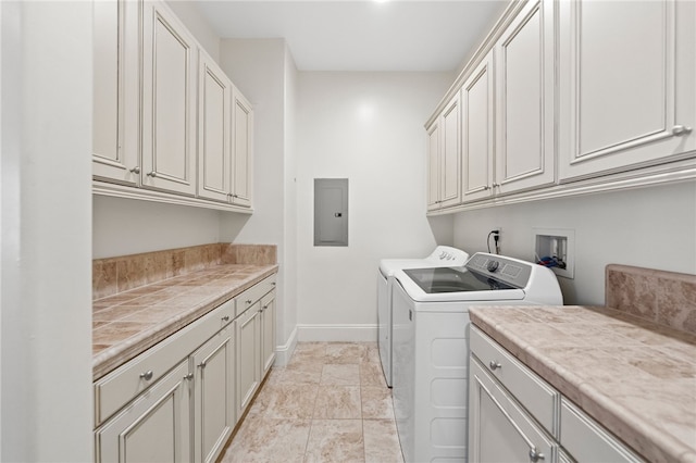 clothes washing area featuring cabinets, washer and clothes dryer, and electric panel