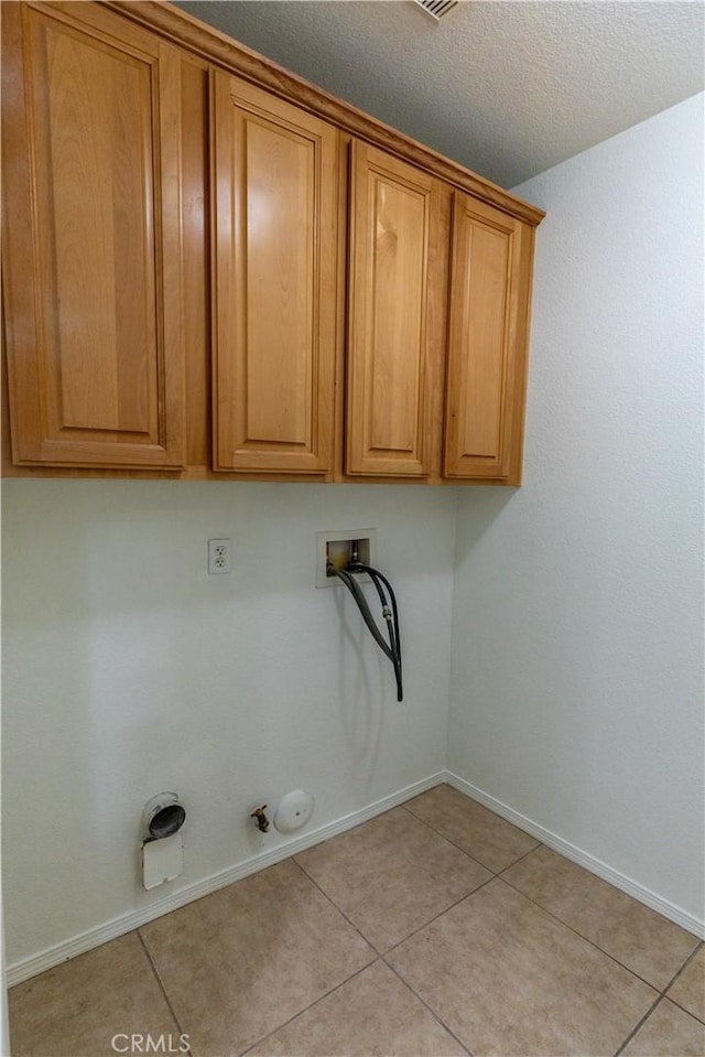 laundry room with washer hookup, cabinets, light tile patterned floors, and gas dryer hookup