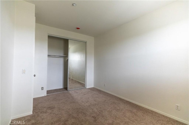 unfurnished bedroom with carpet floors and a closet