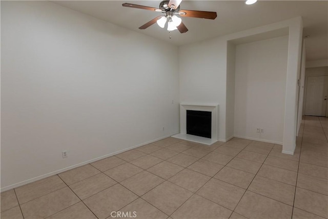 unfurnished living room featuring ceiling fan and light tile patterned floors