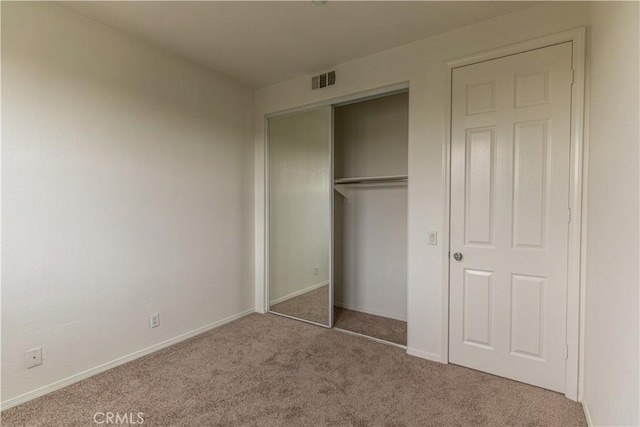 unfurnished bedroom with a closet and carpet flooring