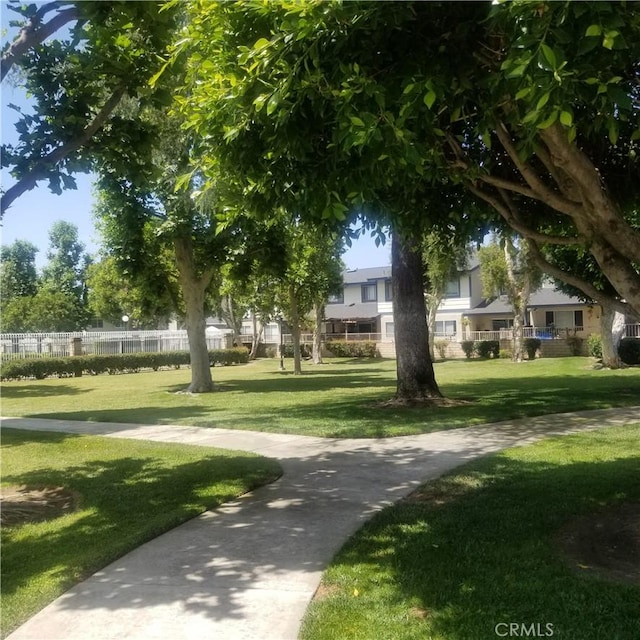 view of home's community with fence and a lawn