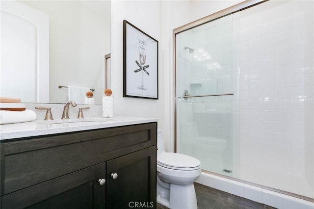 bathroom featuring toilet, tile patterned floors, an enclosed shower, and vanity