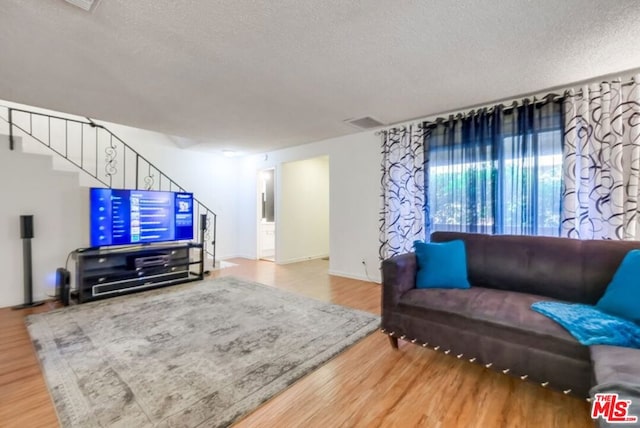 living room featuring hardwood / wood-style flooring and a textured ceiling