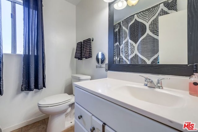 bathroom featuring toilet, tile patterned flooring, and vanity