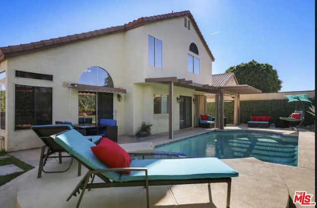 back of property featuring a fenced in pool and a patio