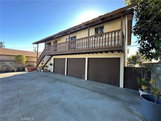 view of side of home featuring a balcony and a garage