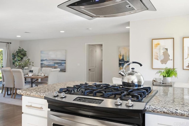 kitchen featuring white cabinets, light stone countertops, stainless steel gas range, and dark hardwood / wood-style floors