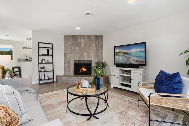 living room with a large fireplace and light hardwood / wood-style floors