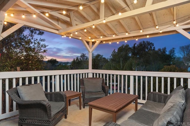 deck at dusk featuring an outdoor hangout area