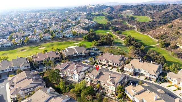 drone / aerial view featuring view of golf course and a residential view