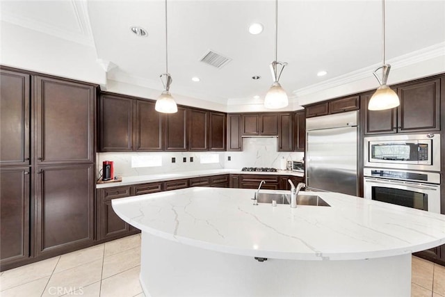 kitchen with a sink, crown molding, built in appliances, and visible vents