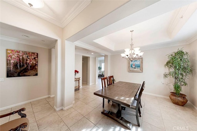 dining space with a tray ceiling, baseboards, ornamental molding, and a chandelier