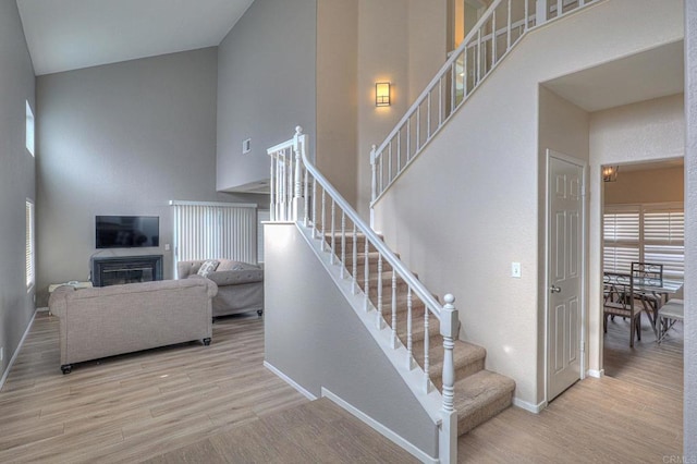 staircase with hardwood / wood-style flooring and a towering ceiling