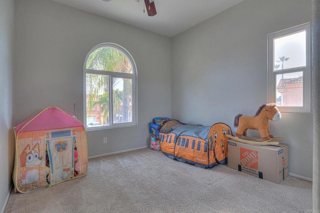 carpeted bedroom featuring ceiling fan and multiple windows