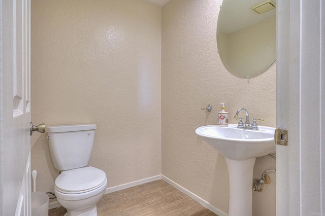 bathroom with wood-type flooring and toilet