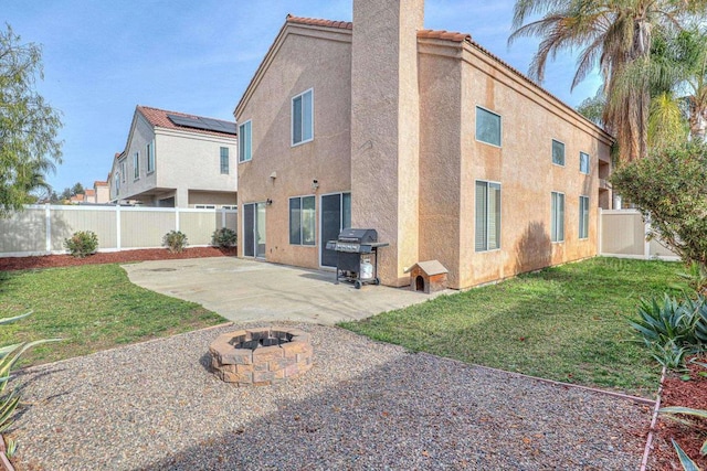 back of property featuring a patio area, an outdoor fire pit, and a lawn