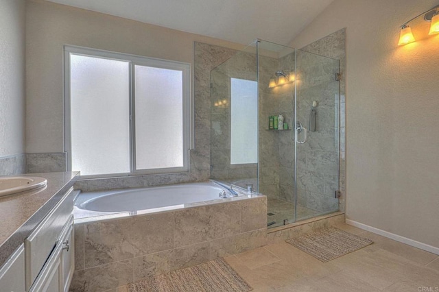 bathroom with vaulted ceiling, independent shower and bath, tile patterned floors, and vanity