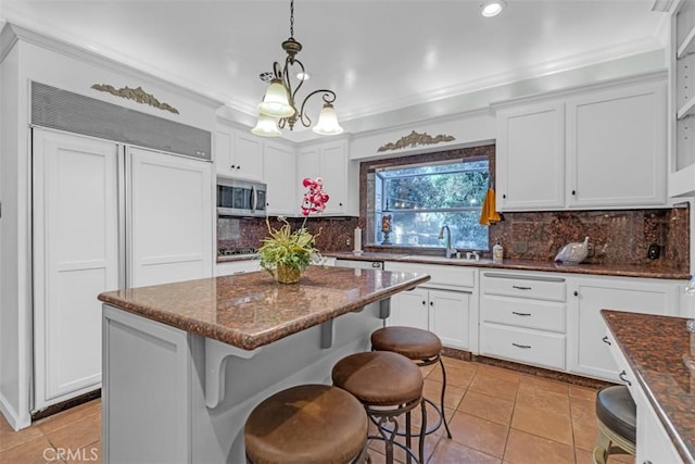 kitchen featuring a kitchen island, white cabinets, and hanging light fixtures