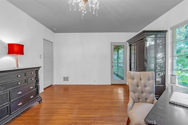 sitting room with hardwood / wood-style flooring and a notable chandelier