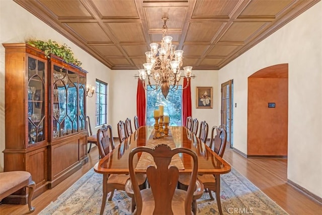 dining room featuring coffered ceiling, a notable chandelier, and light wood-type flooring