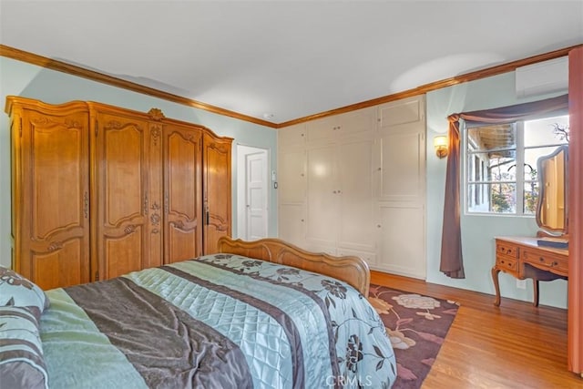 bedroom featuring a closet, an AC wall unit, crown molding, and light hardwood / wood-style flooring