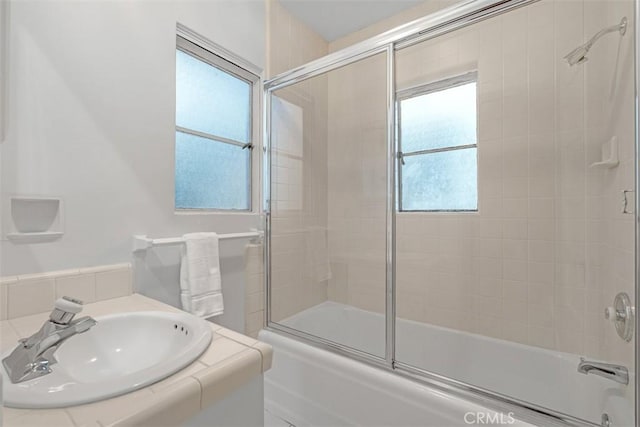 bathroom featuring sink and combined bath / shower with glass door